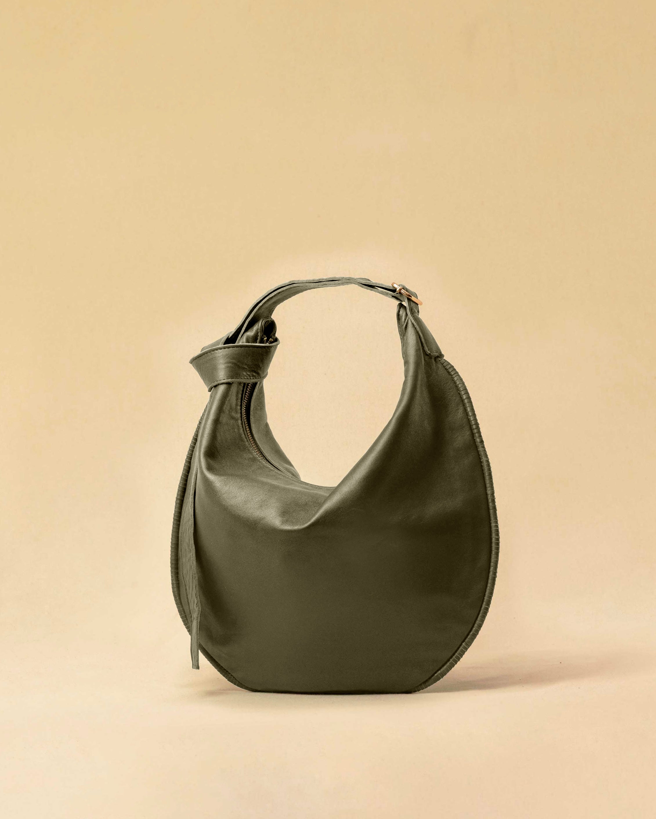 The Saddle Bag IVY by LABEL17 is crafted from supple, vegetable-tanned nappa leather and defined by its distinctive hand-stitched side seams. Its softly curved saddle silhouette rests comfortably against the body. The bag features a zip closure, a leather-lined interior, and a secure inner pocket. The adjustable strap allows it to be worn over the shoulder or crossbody – a versatile piece for everyday use. Handmade in Morocco.