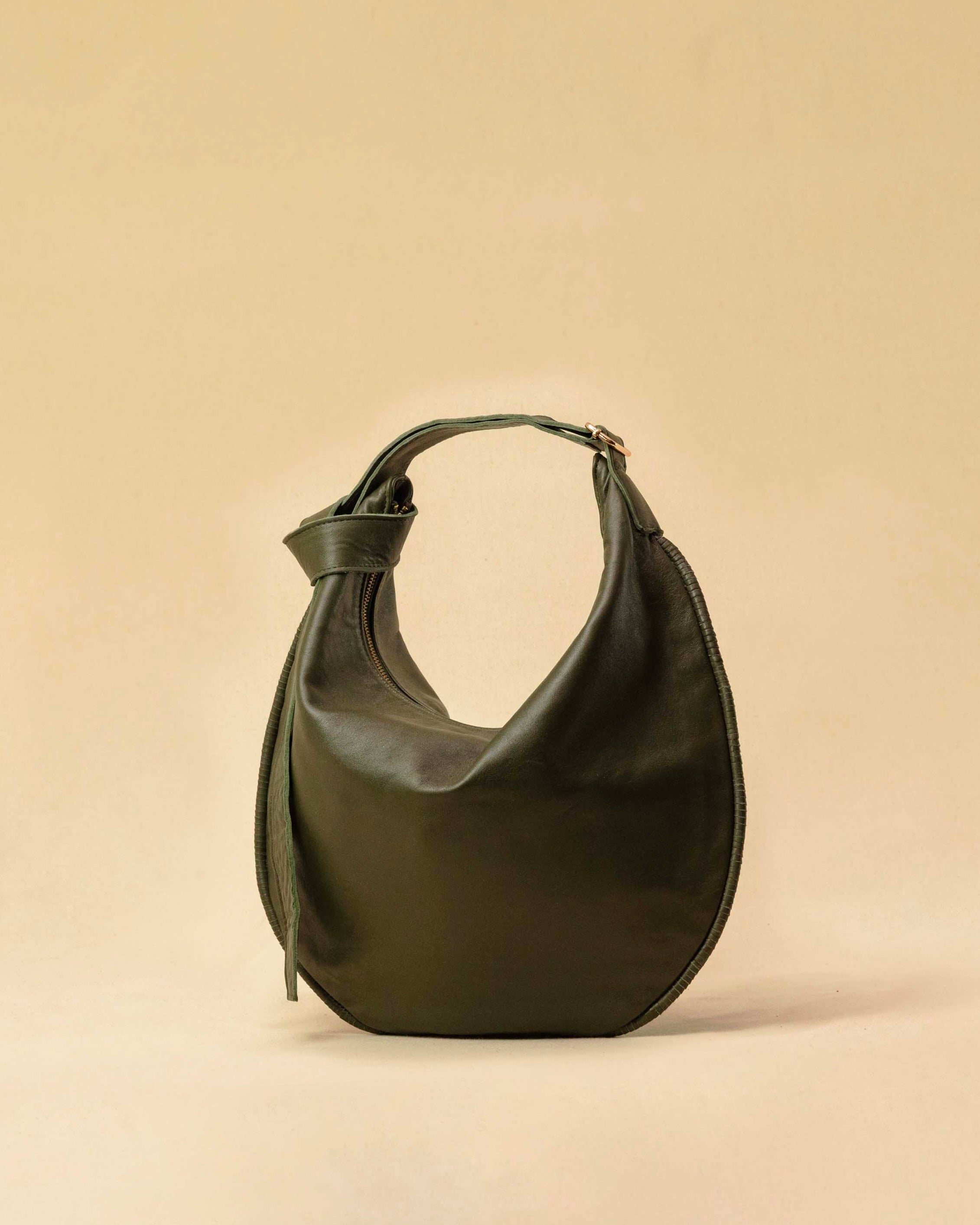 The Saddle Bag IVY by LABEL17 is crafted from supple, vegetable-tanned nappa leather and defined by its distinctive hand-stitched side seams. Its softly curved saddle silhouette rests comfortably against the body. The bag features a zip closure, a leather-lined interior, and a secure inner pocket. The adjustable strap allows it to be worn over the shoulder or crossbody – a versatile piece for everyday use. Handmade in Morocco.