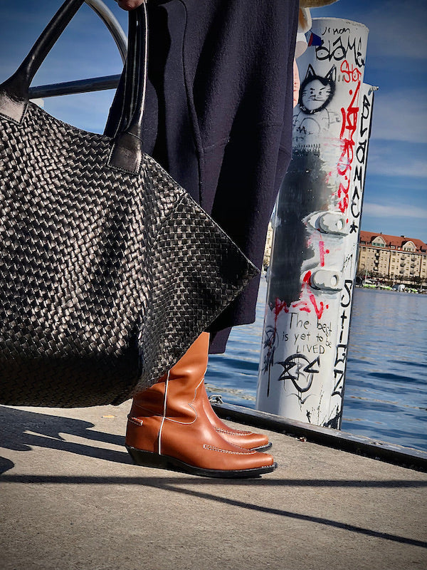 The Shoulder Bag ORIGINAL XL (Weekender) by LABEL17 is made from supple, vegetable-tanned nappa leather. The hand-braided leather bag can be made smaller on both sides from the inside with press studs and also includes a detachable, hand-braided pouch for organization inside the bag.