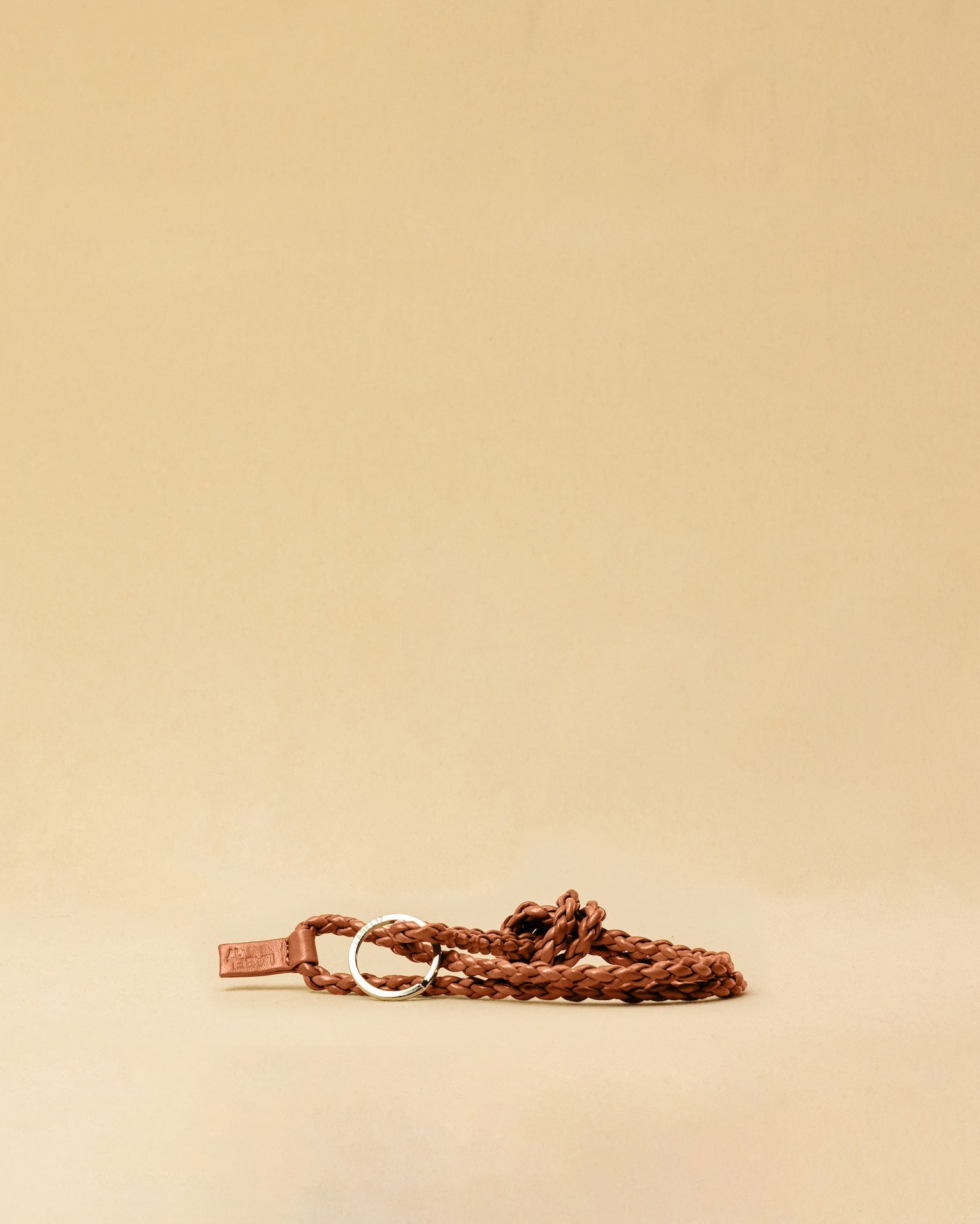 Schlüsselanhänger CLARA in Cognac von LABEL17, von Hand geflochten, gefertigt aus Nappaleder. Länge: ca. 50 cm. Langlebig und zeitlos, handgefertigt in Marokko.