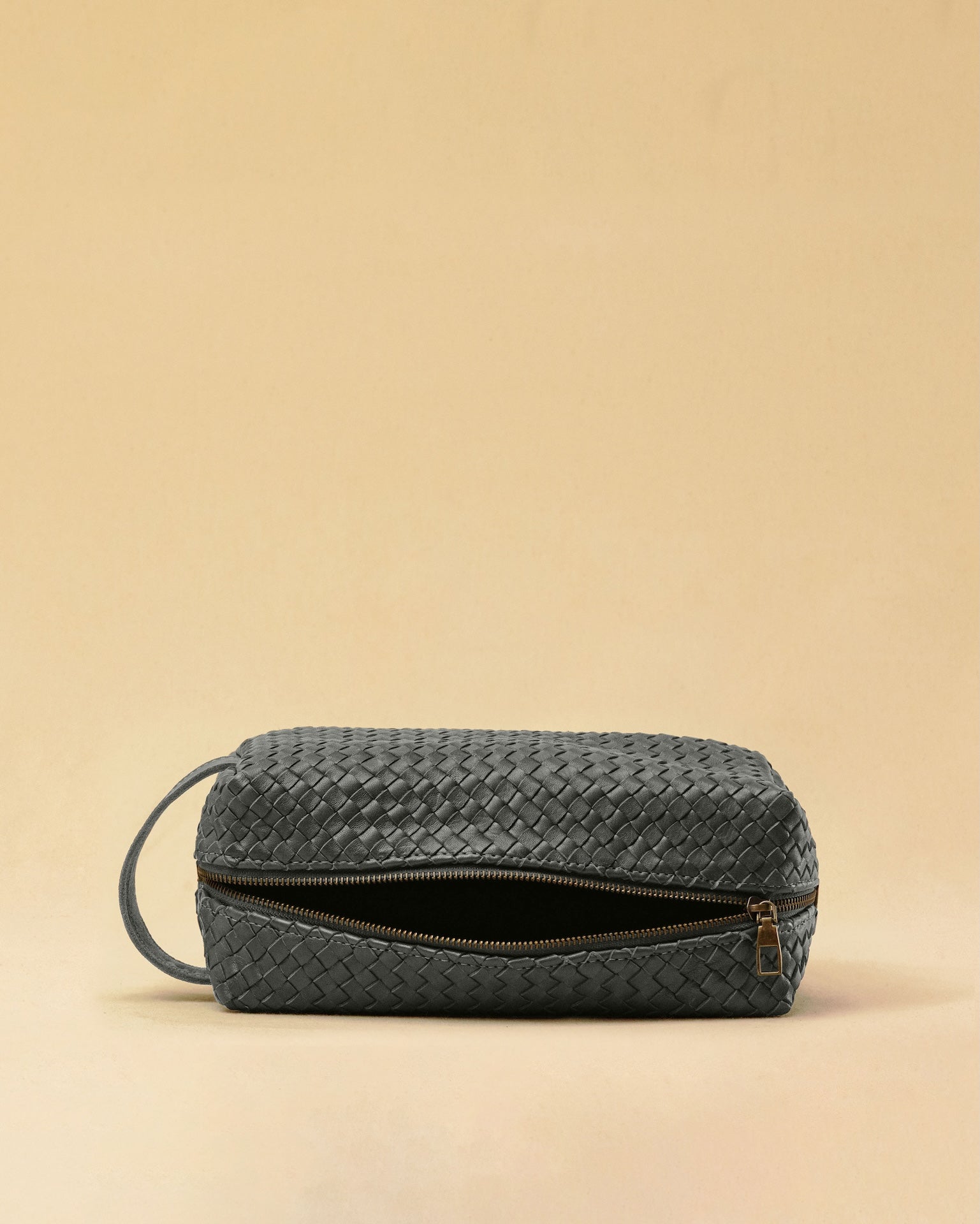 Die Braided Travel Pouch VOYAGER überzeugt mit strukturierter Form und seitlichen Innenfächern – ideal für Reise-Essentials. Das Leder ist von Hand geflochten, das Innere mit robustem Nylon ausgekleidet. Stilvoll und durchdacht.