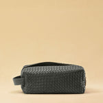 Die Braided Travel Pouch VOYAGER überzeugt mit strukturierter Form und seitlichen Innenfächern – ideal für Reise-Essentials. Das Leder ist von Hand geflochten, das Innere mit robustem Nylon ausgekleidet. Stilvoll und durchdacht.