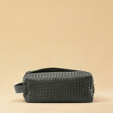 Die Braided Travel Pouch VOYAGER überzeugt mit strukturierter Form und seitlichen Innenfächern – ideal für Reise-Essentials. Das Leder ist von Hand geflochten, das Innere mit robustem Nylon ausgekleidet. Stilvoll und durchdacht.