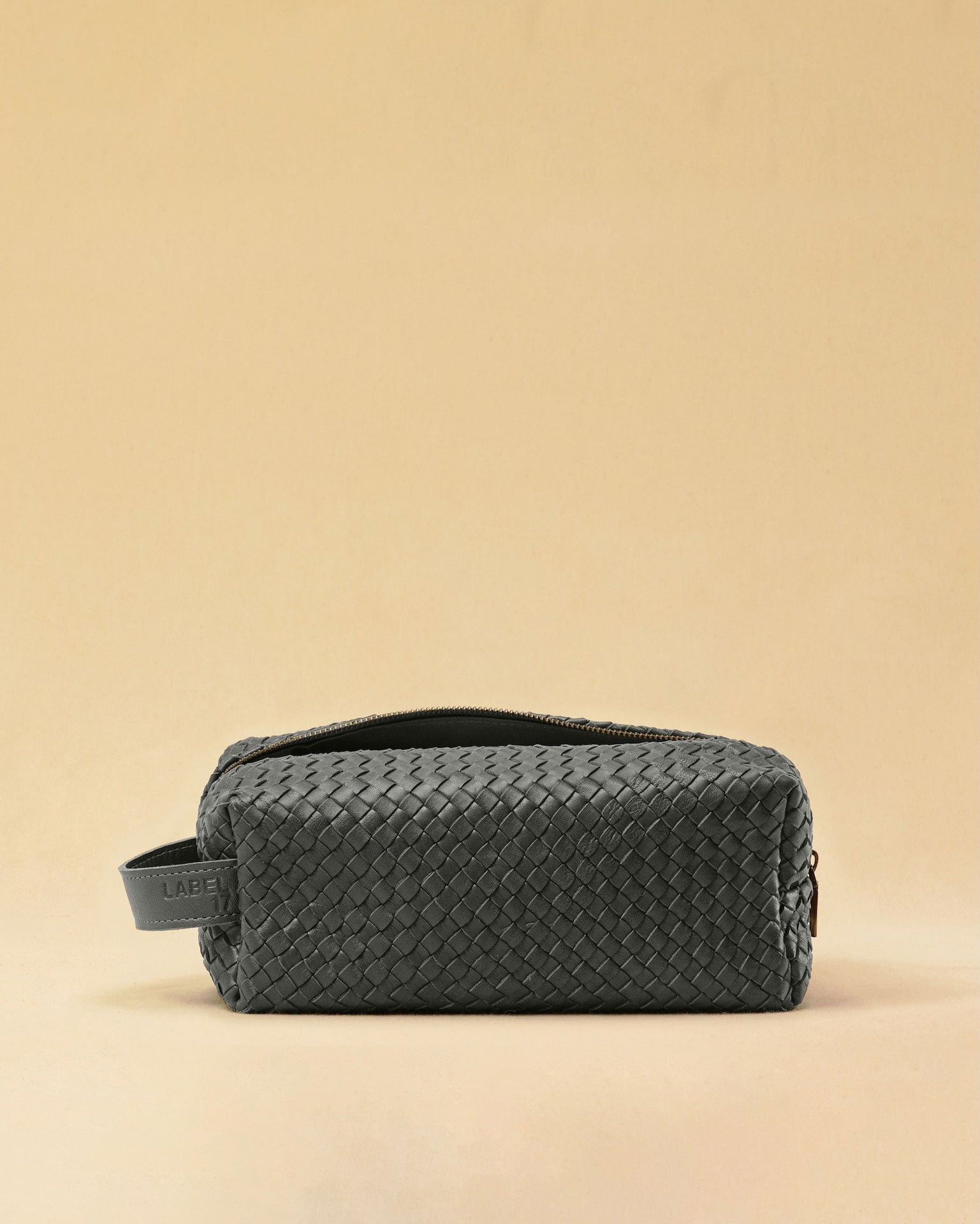 Die Braided Travel Pouch VOYAGER überzeugt mit strukturierter Form und seitlichen Innenfächern – ideal für Reise-Essentials. Das Leder ist von Hand geflochten, das Innere mit robustem Nylon ausgekleidet. Stilvoll und durchdacht.