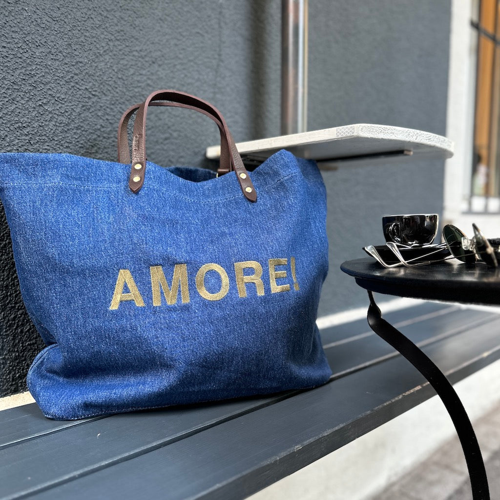 Bestickte Stofftasche von LABEL17 mit braunen Lederhenkeln und AMORE Botschaft auf der Vorderseite. Hergestellt in Marokko