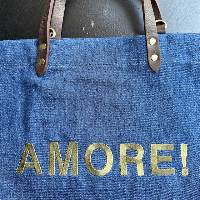 Bestickte Stofftasche von LABEL17 mit braunen Lederhenkeln und AMORE Botschaft auf der Vorderseite. Hergestellt in Marokko