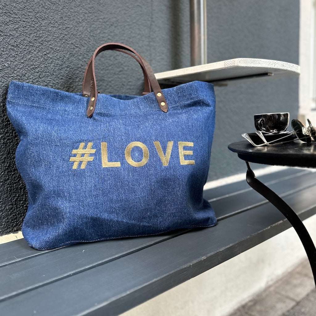 Bestickte Stofftasche von LABEL17 mit braunen Lederhenkeln und #LOVE Botschaft auf der Vorderseite. Hergestellt in Marokko
