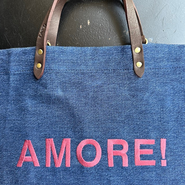 Bestickte Stofftasche von LABEL17 mit braunen Lederhenkeln und AMORE Botschaft auf der Vorderseite. Hergestellt in Marokko