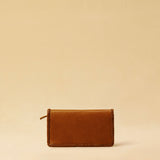 The Portemonnaie IVY by LABEL17 is crafted from supple, vegetable-tanned nappa leather and defined by its distinctive hand-stitched side seams. It features a spacious zip compartment and a card section, with an additional large pocket behind it – perfect for holding a passport or travel documents. A functional companion for everyday life – and the perfect partner for travel. Handmade in Morocco.