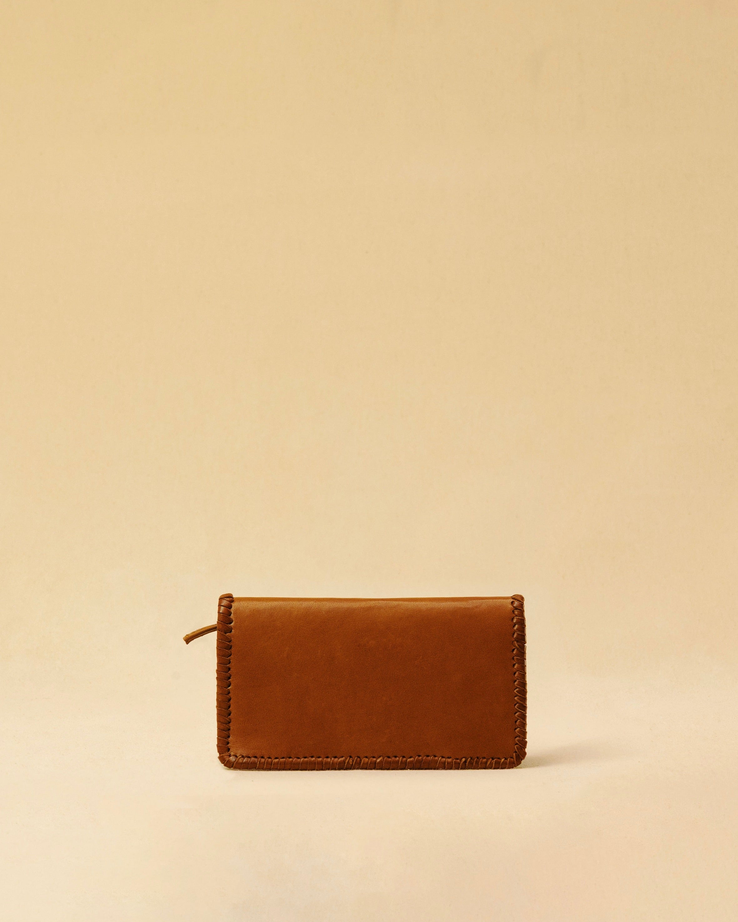 The Portemonnaie IVY by LABEL17 is crafted from supple, vegetable-tanned nappa leather and defined by its distinctive hand-stitched side seams. It features a spacious zip compartment and a card section, with an additional large pocket behind it – perfect for holding a passport or travel documents. A functional companion for everyday life – and the perfect partner for travel. Handmade in Morocco.
