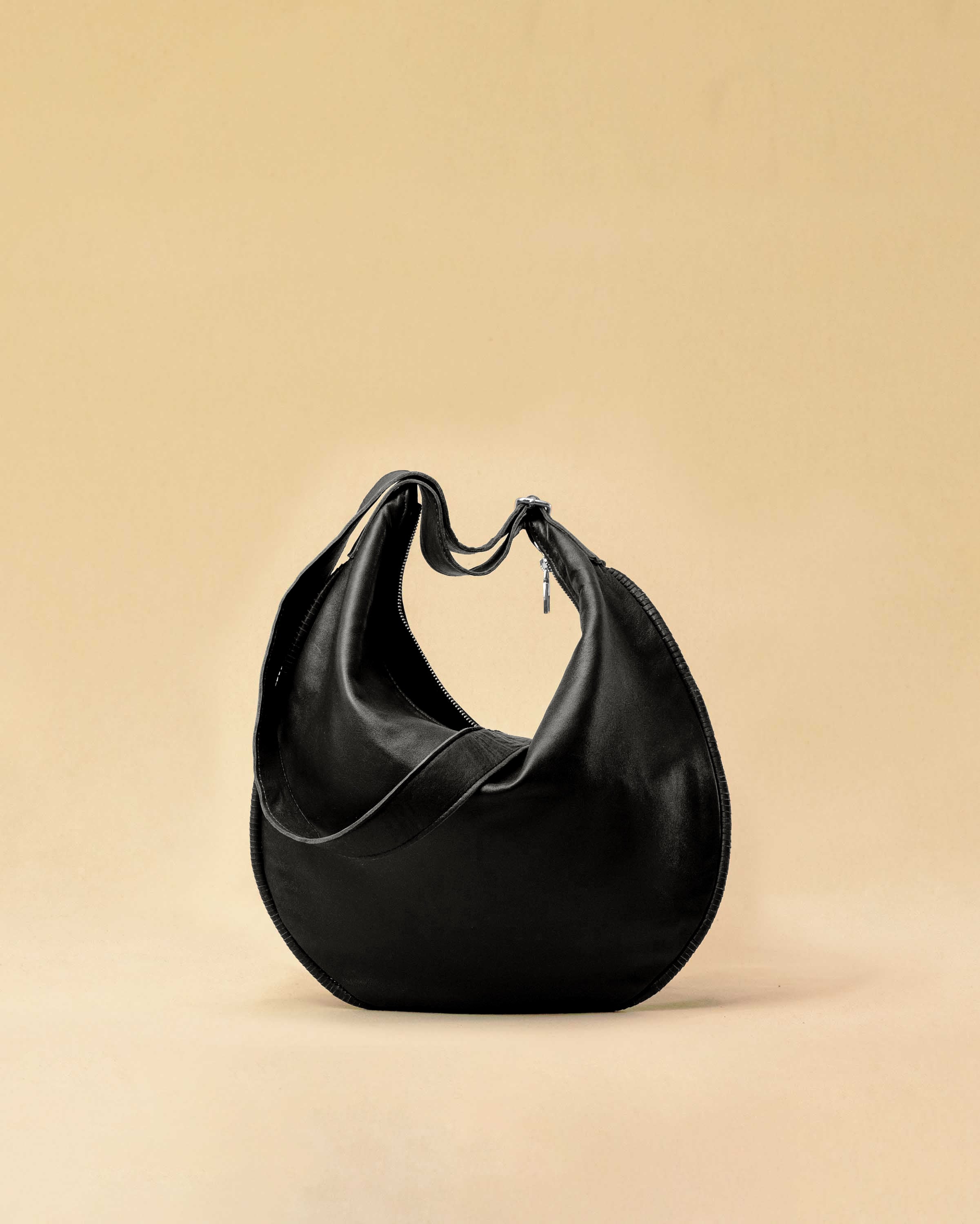 The Saddle Bag IVY by LABEL17 is crafted from supple, vegetable-tanned nappa leather and defined by its distinctive hand-stitched side seams. Its softly curved saddle silhouette rests comfortably against the body. The bag features a zip closure, a leather-lined interior, and a secure inner pocket. The adjustable strap allows it to be worn over the shoulder or crossbody – a versatile piece for everyday use. Handmade in Morocco.