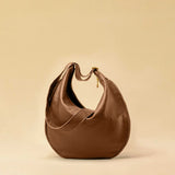 The Saddle Bag IVY by LABEL17 is crafted from supple, vegetable-tanned nappa leather and defined by its distinctive hand-stitched side seams. Its softly curved saddle silhouette rests comfortably against the body. The bag features a zip closure, a leather-lined interior, and a secure inner pocket. The adjustable strap allows it to be worn over the shoulder or crossbody – a versatile piece for everyday use. Handmade in Morocco.