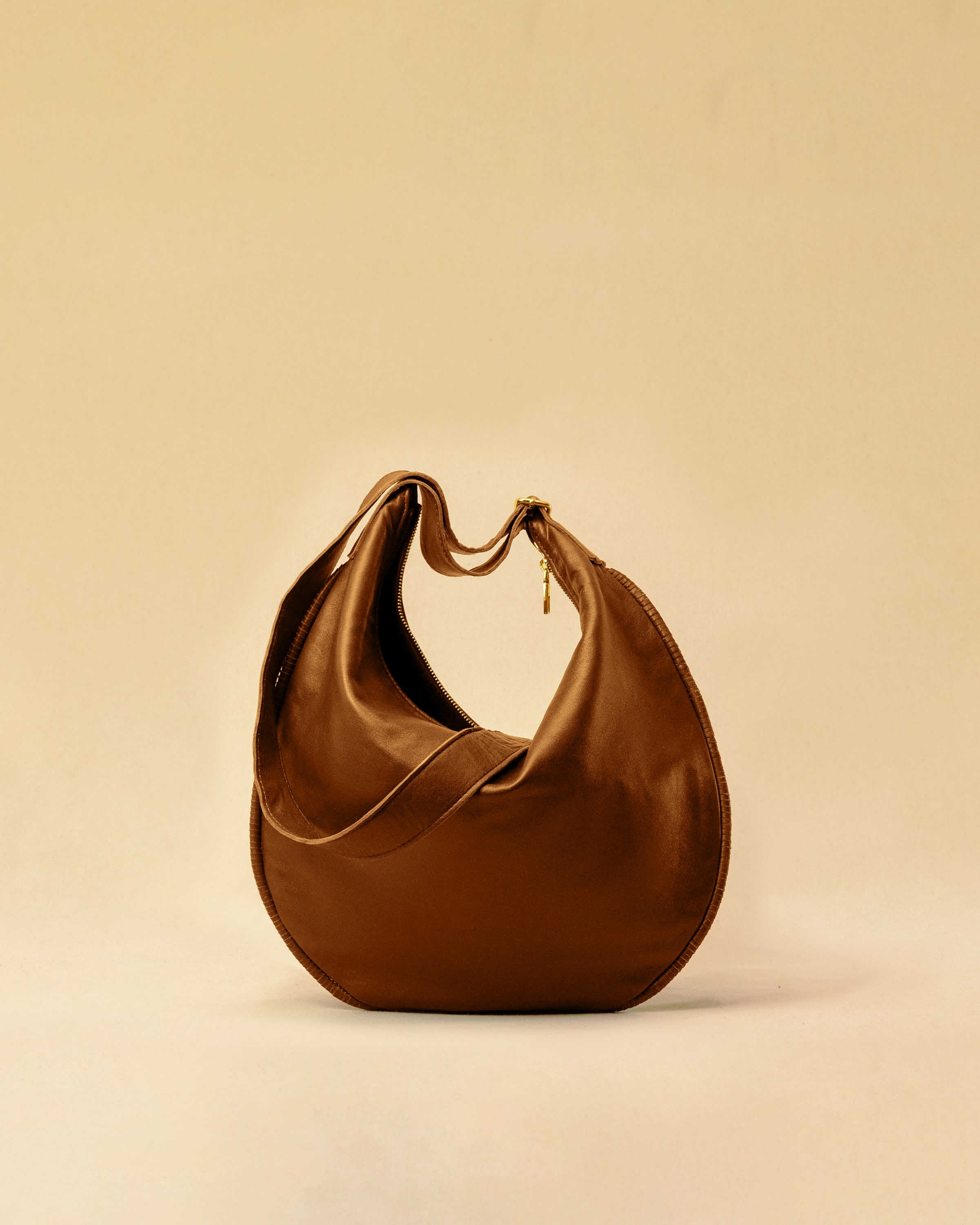 The Saddle Bag IVY by LABEL17 is crafted from supple, vegetable-tanned nappa leather and defined by its distinctive hand-stitched side seams. Its softly curved saddle silhouette rests comfortably against the body. The bag features a zip closure, a leather-lined interior, and a secure inner pocket. The adjustable strap allows it to be worn over the shoulder or crossbody – a versatile piece for everyday use. Handmade in Morocco.