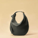 The Saddle Bag IVY by LABEL17 is crafted from supple, vegetable-tanned nappa leather and defined by its distinctive hand-stitched side seams. Its softly curved saddle silhouette rests comfortably against the body. The bag features a zip closure, a leather-lined interior, and a secure inner pocket. The adjustable strap allows it to be worn over the shoulder or crossbody – a versatile piece for everyday use. Handmade in Morocco.
