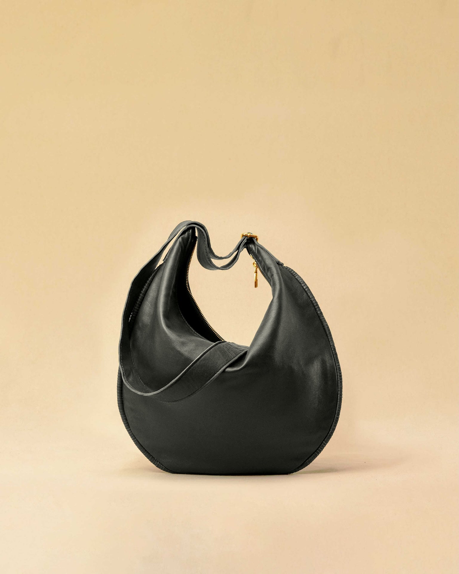 The Saddle Bag IVY by LABEL17 is crafted from supple, vegetable-tanned nappa leather and defined by its distinctive hand-stitched side seams. Its softly curved saddle silhouette rests comfortably against the body. The bag features a zip closure, a leather-lined interior, and a secure inner pocket. The adjustable strap allows it to be worn over the shoulder or crossbody – a versatile piece for everyday use. Handmade in Morocco.