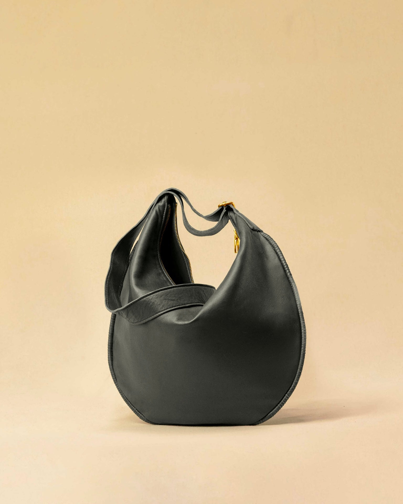 The Saddle Bag IVY by LABEL17 is crafted from supple, vegetable-tanned nappa leather and defined by its distinctive hand-stitched side seams. Its softly curved saddle silhouette rests comfortably against the body. The bag features a zip closure, a leather-lined interior, and a secure inner pocket. The adjustable strap allows it to be worn over the shoulder or crossbody – a versatile piece for everyday use. Handmade in Morocco.