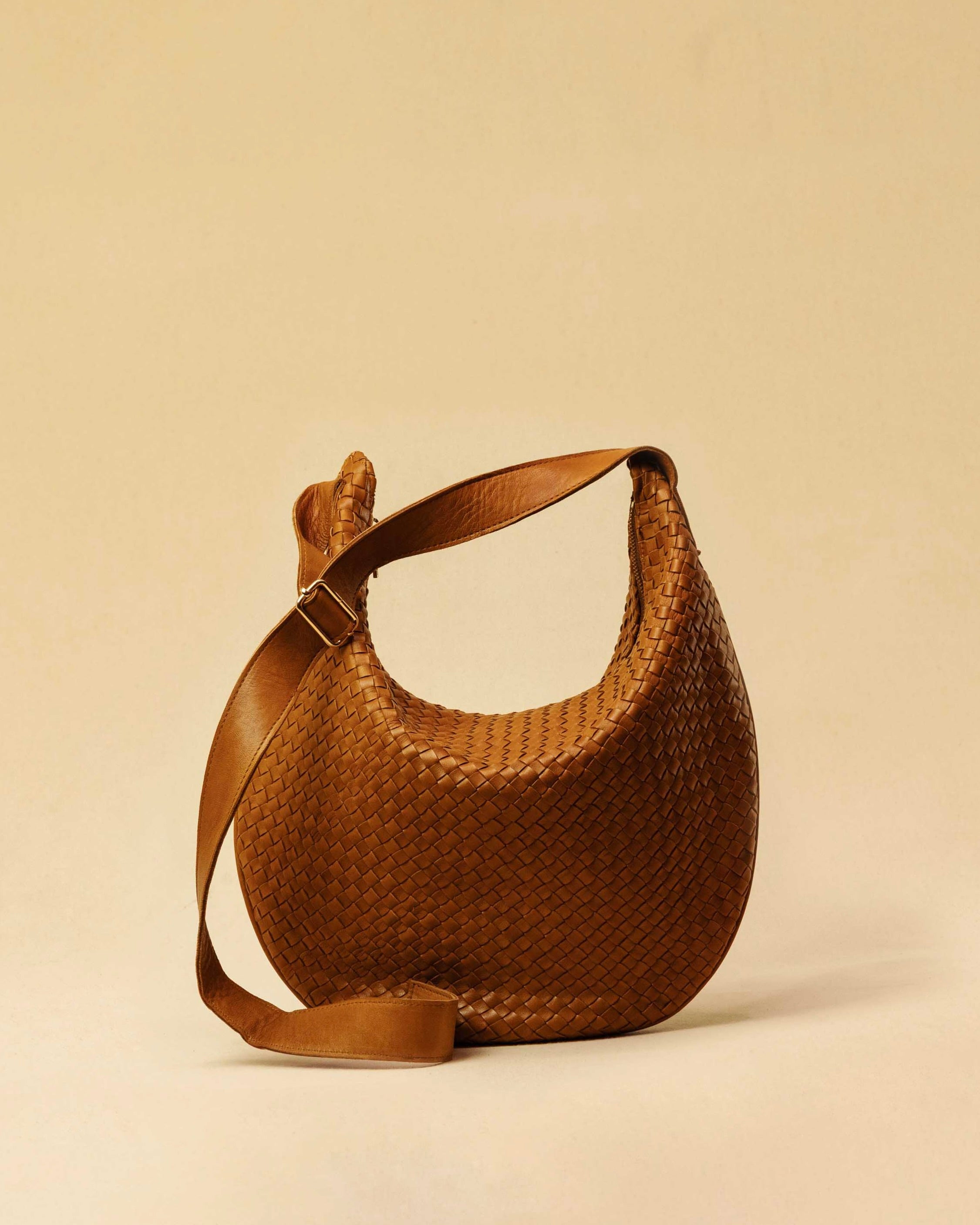 The Saddle Bag LUNA by LABEL17 is hand-braided from the finest vegetable-tanned nappa leather. Its softly curved saddle shape is elegantly defined by a delicate piped seam, allowing it to rest comfortably against the body. It features a zip closure, a leather-lined interior, and a secure inner pocket. The adjustable strap allows for shoulder or crossbody wear – a versatile companion for every day. Handmade in Morocco.