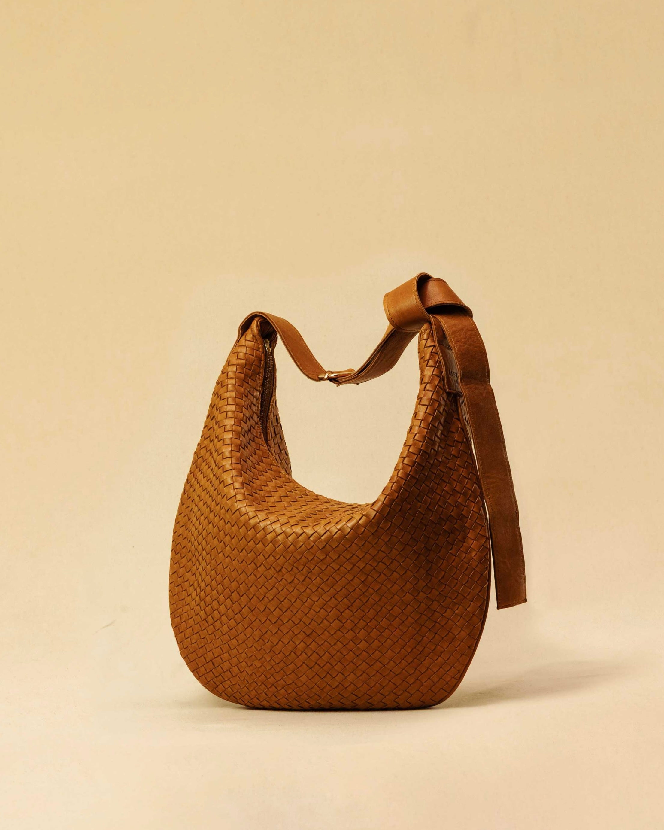 The Saddle Bag LUNA by LABEL17 is hand-braided from the finest vegetable-tanned nappa leather. Its softly curved saddle shape is elegantly defined by a delicate piped seam, allowing it to rest comfortably against the body. It features a zip closure, a leather-lined interior, and a secure inner pocket. The adjustable strap allows for shoulder or crossbody wear – a versatile companion for every day. Handmade in Morocco.