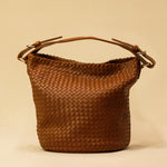 Shoulder Bag ABBIE in Cognac von LABEL17, aus geschmeidigem Lamm-Nappaleder von Hand geflochten. Beutelform mit kurzem Schulterhenkel, hergestellt in Marokko.