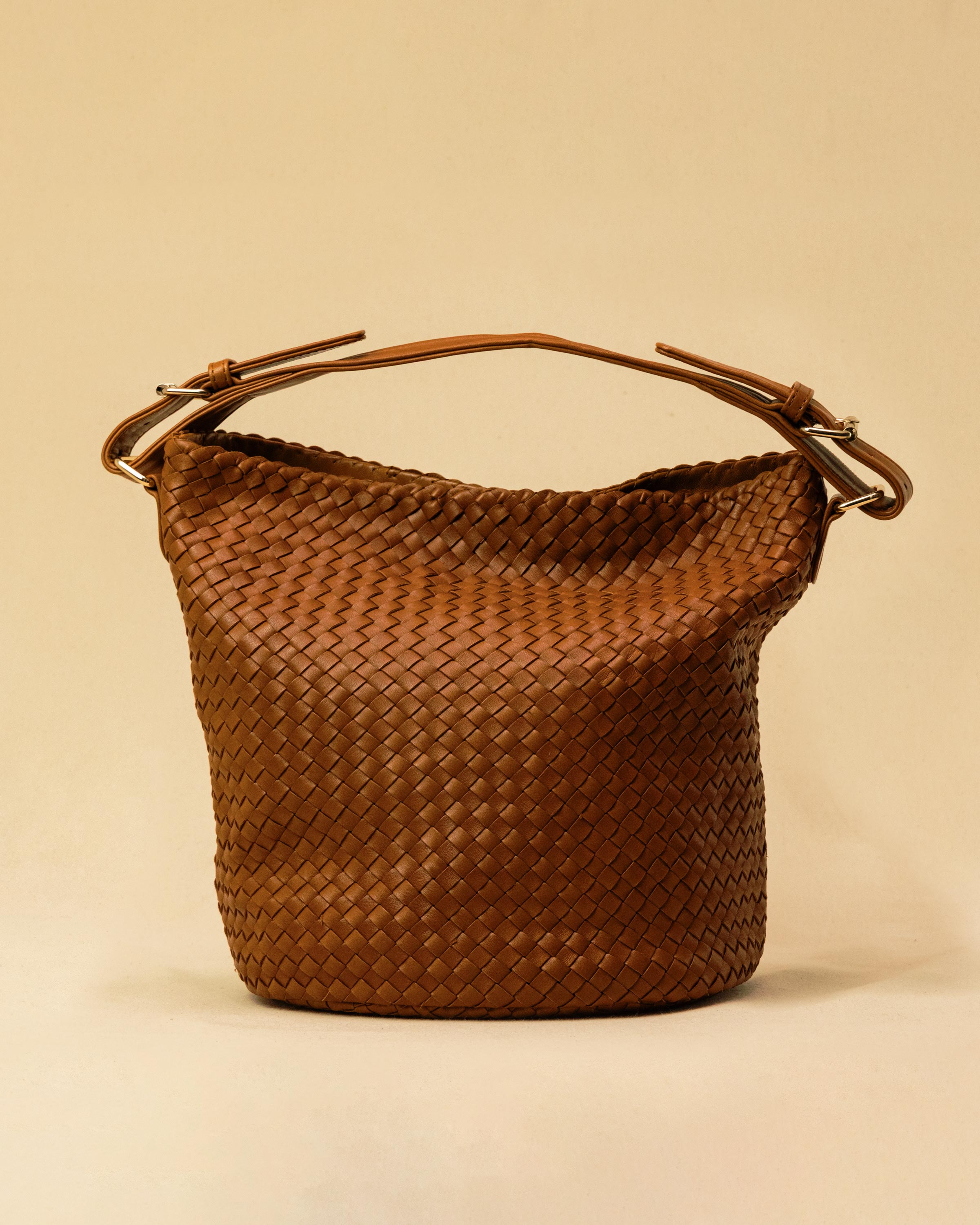 Shoulder Bag ABBIE in Cognac von LABEL17, aus geschmeidigem Lamm-Nappaleder von Hand geflochten. Beutelform mit kurzem Schulterhenkel, hergestellt in Marokko.