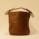 Shoulder Bag ABBIE in Cognac von LABEL17, aus geschmeidigem Lamm-Nappaleder von Hand geflochten. Beutelform mit kurzem Schulterhenkel, hergestellt in Marokko.