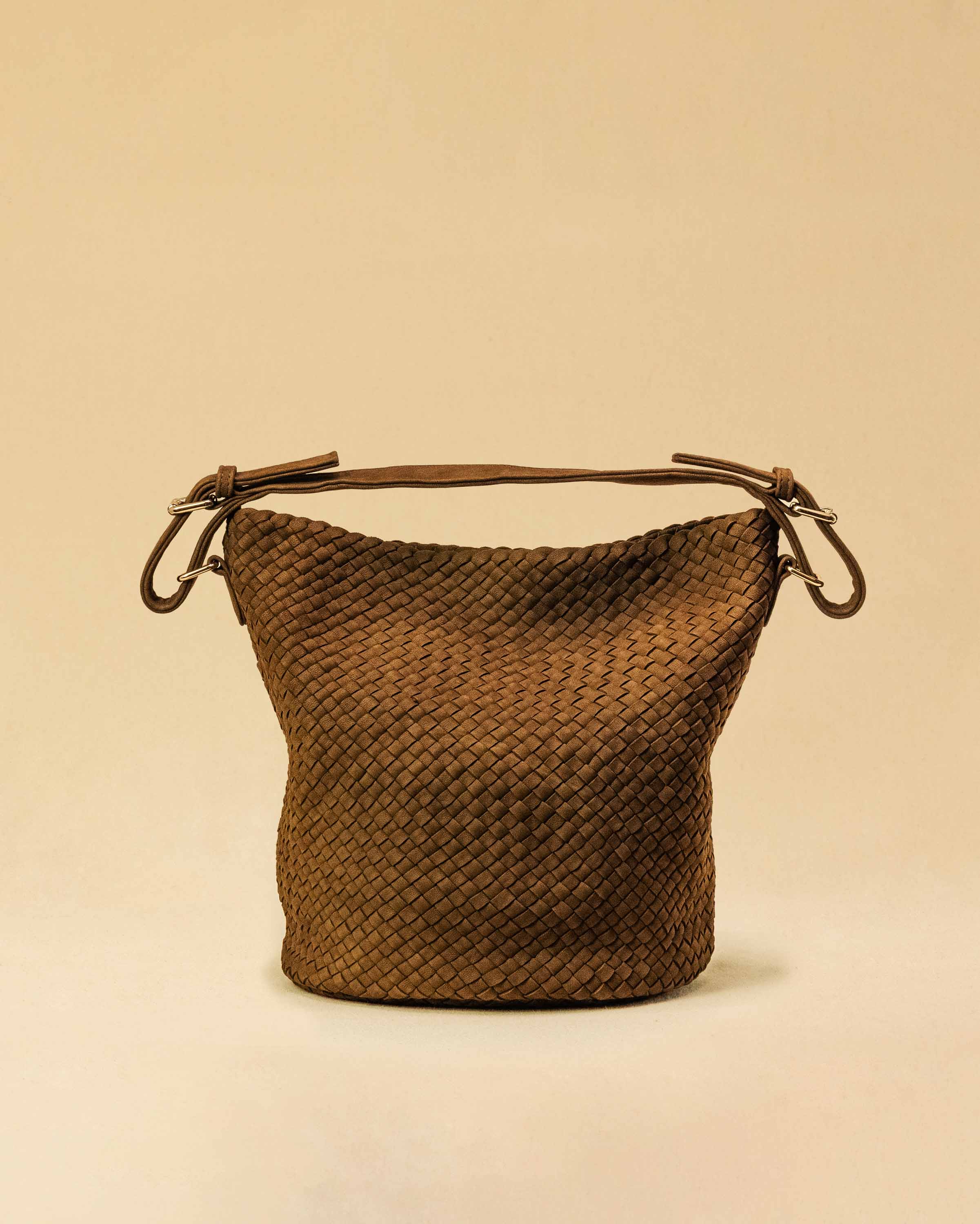 Die Shoulder Bag ABBIE ist aus geschmeidigem Lamm-Suede-Leder von Hand geflochten. Ihre weiche Beutelform wird mit einem kurzen Schulterhenkel getragen – wahlweise in der Hand oder lässig über der Schulter.
