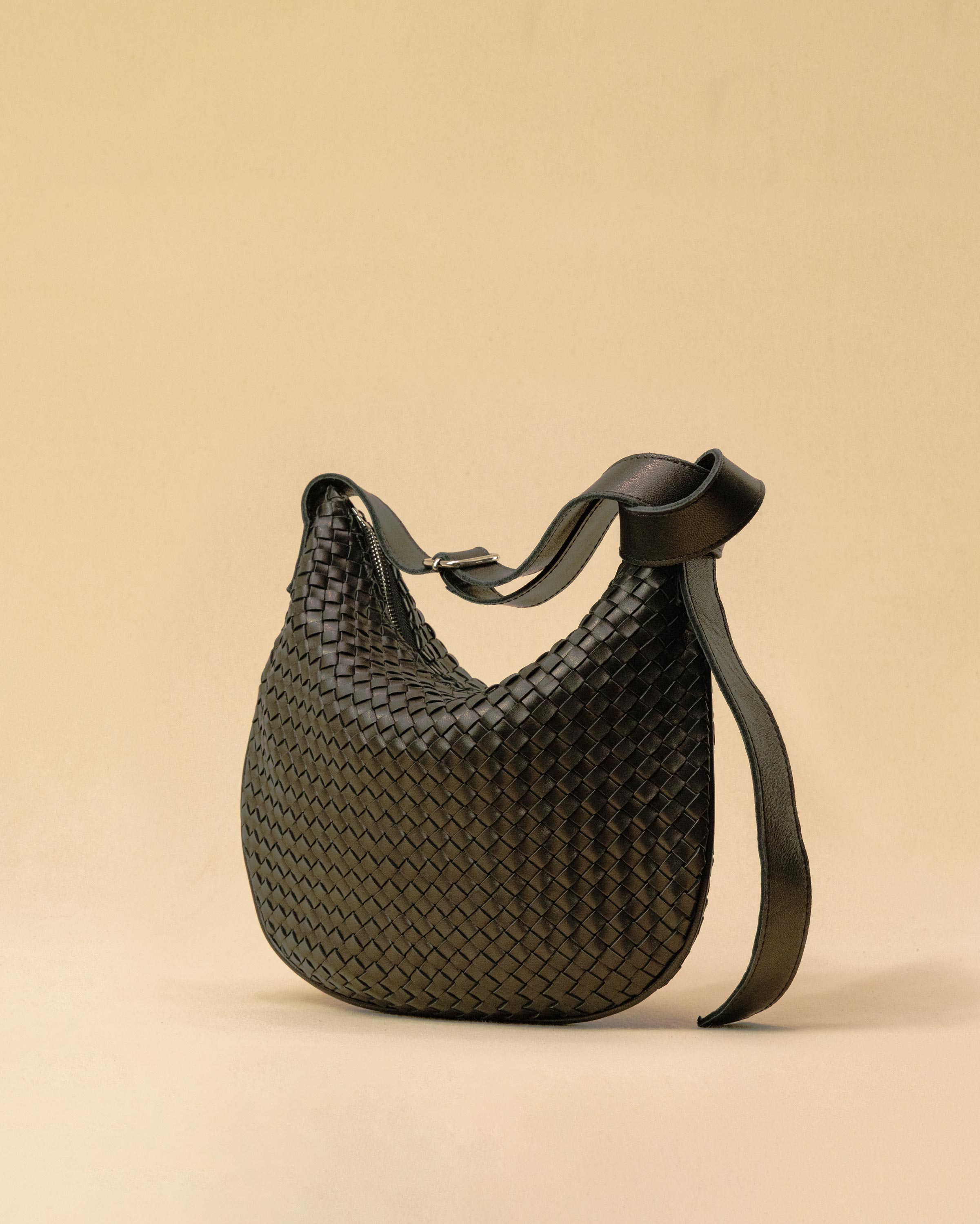 Die SHOULDER BAG SADDLE LUNA Medium in Black von LABEL17 ist aus feinstem, pflanzlich gegerbtem Nappaleder von Hand geflochten. Die Tasche hat einen Reissverschluss und einen ledergefütterten Innenraum mit Seitenfach. Dank dem verstellbaren Schulterriemen ist sie als Schultertasche oder Crossbody zu tragen.