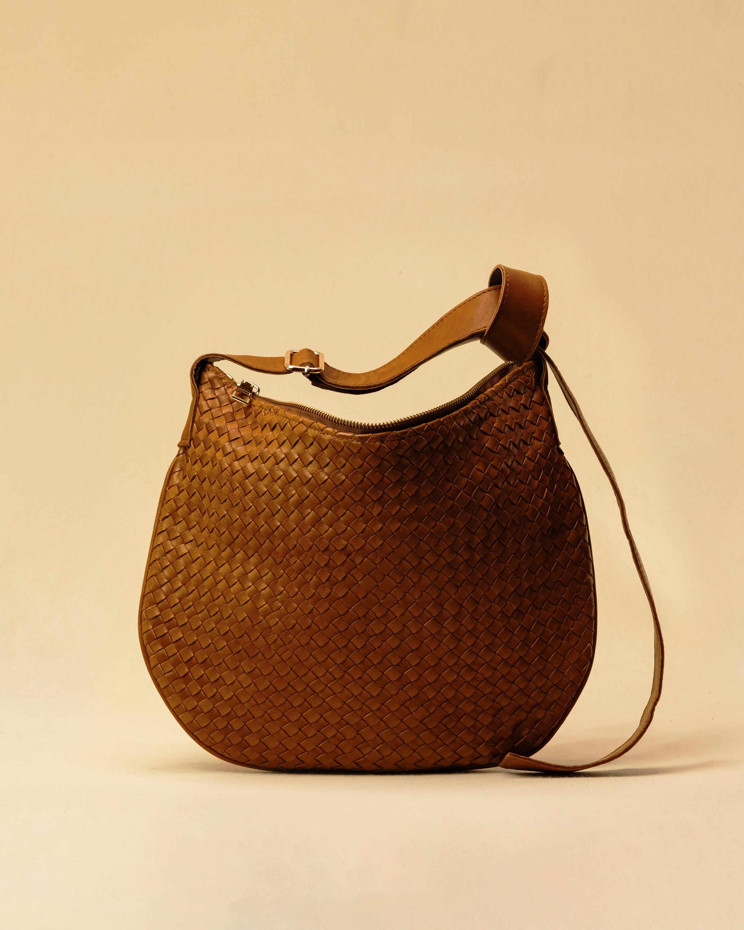 Die SHOULDER BAG SADDLE LUNA Medium in Cognac von LABEL17 ist aus feinstem, pflanzlich gegerbtem Nappaleder von Hand geflochten. Die Tasche hat einen Reissverschluss und einen ledergefütterten Innenraum mit Seitenfach. Dank dem verstellbaren Schulterriemen ist sie als Schultertasche oder Crossbody zu tragen.