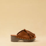 Clogs CHOUCHA in Cognac by LABEL17, crafted from supple, vegetable-tanned lamb nappa leather. A large, soft pompom on top swings elegantly from left to right with each step, adding a playful yet refined touch. The shoe features a durable sole for comfort and stability. The artisanal craftsmanship enhances the overall aesthetic, making these clogs a true statement piece. Quiet luxury at its best. Handmade in Greece.