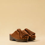 Clogs CHOUCHA in Cognac by LABEL17, crafted from supple, vegetable-tanned lamb nappa leather. A large, soft pompom on top swings elegantly from left to right with each step, adding a playful yet refined touch. The shoe features a durable sole for comfort and stability. The artisanal craftsmanship enhances the overall aesthetic, making these clogs a true statement piece. Quiet luxury at its best. Handmade in Greece.