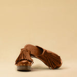 Clogs CHOUCHA in Cognac by LABEL17, crafted from supple, vegetable-tanned lamb nappa leather. A large, soft pompom on top swings elegantly from left to right with each step, adding a playful yet refined touch. The shoe features a durable sole for comfort and stability. The artisanal craftsmanship enhances the overall aesthetic, making these clogs a true statement piece. Quiet luxury at its best. Handmade in Greece.