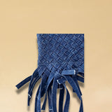 Die Crossbody Bag Tresse Fringes Denim von LABEL17 mit geflochtenen Henkeln und langem abnehmbarem Schulterriemen, ist aus gewaschenem Denim gefertigt und von Hand geflochten.