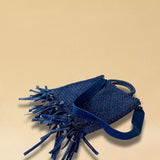 Die Crossbody Bag Tresse Fringes Denim von LABEL17 mit geflochtenen Henkeln und langem abnehmbarem Schulterriemen, ist aus gewaschenem Denim gefertigt und von Hand geflochten.