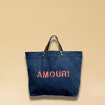 Bestickte Stofftasche von LABEL17 mit braunen Lederhenkeln und AMOUR 
Botschaft auf der Vorderseite. Hergestellt in Marokko