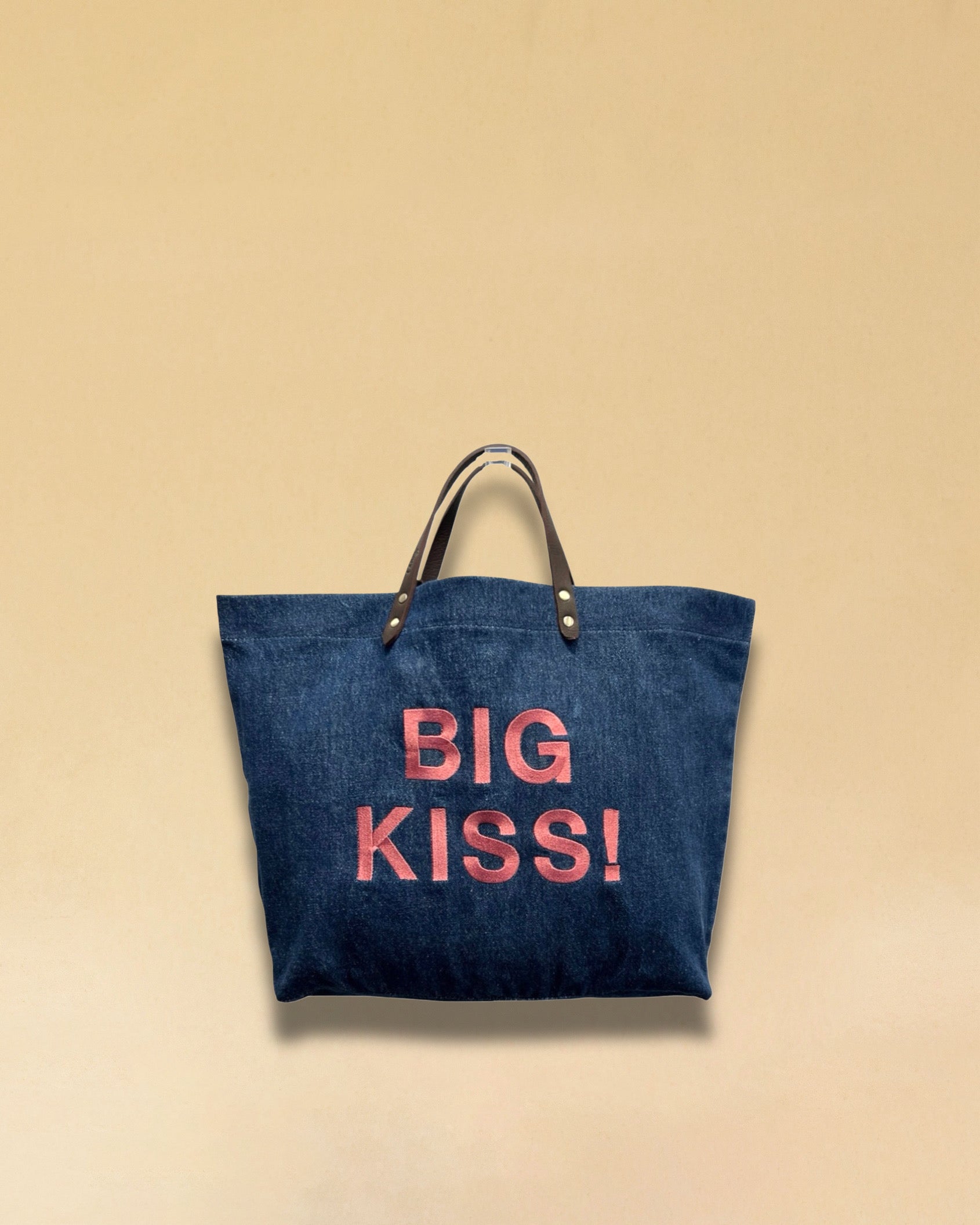 Bestickte Stofftasche von LABEL17 mit braunen Lederhenkeln und BIG KISS Botschaft auf der Vorderseite. Hergestellt in Marokko