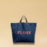 Bestickte Stofftasche von LABEL17 mit braunen Lederhenkeln und #LOVE Botschaft auf der Vorderseite. Hergestellt in Marokko