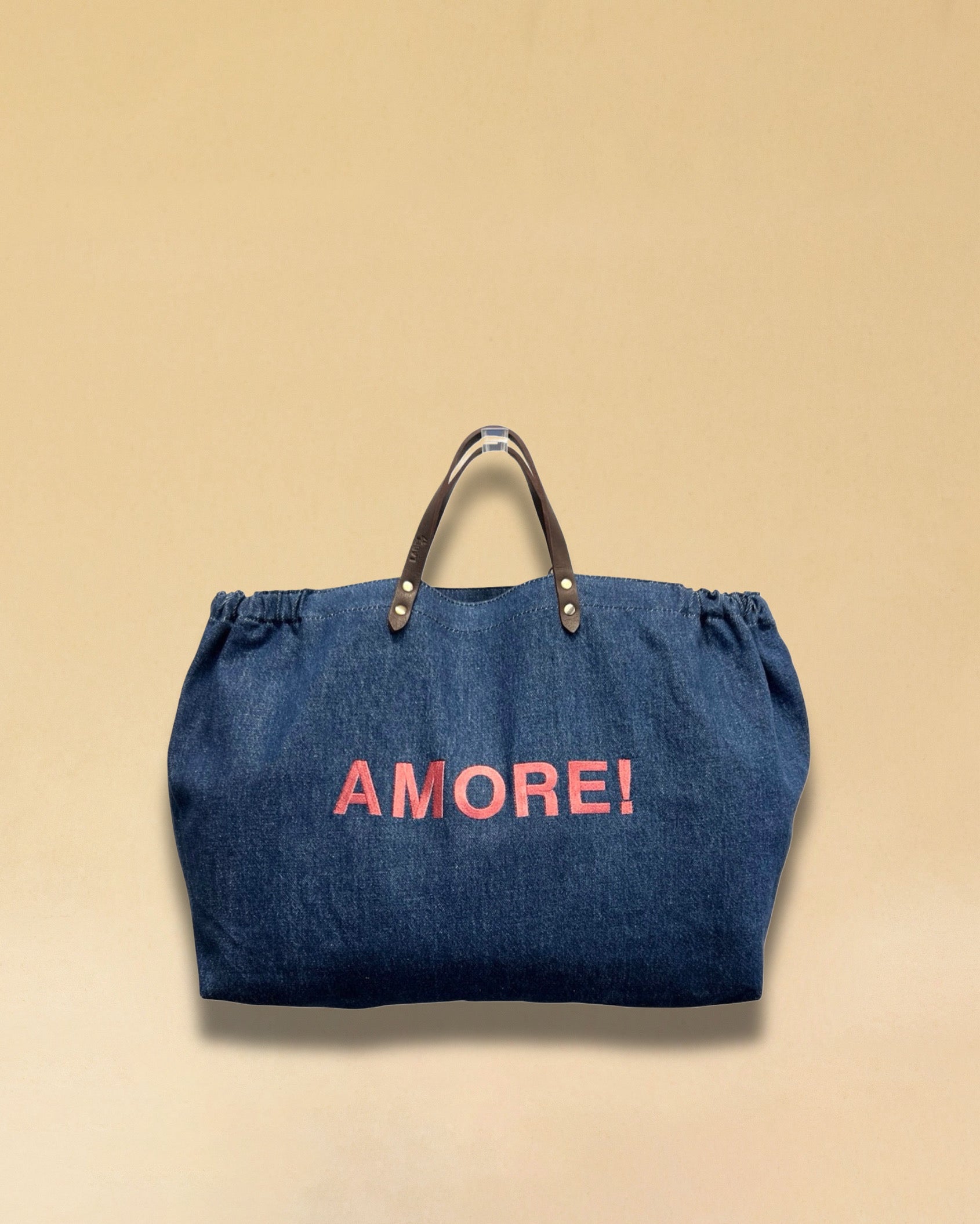 Bestickte Stofftasche von LABEL17 mit braunen Lederhenkeln und AMORE Botschaft auf der Vorderseite. Hergestellt in Marokko