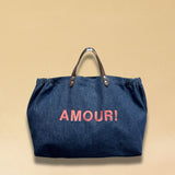 Bestickte Stofftasche von LABEL17 mit braunen Lederhenkeln und AMOUR Botschaft auf der Vorderseite. Hergestellt in Marokko