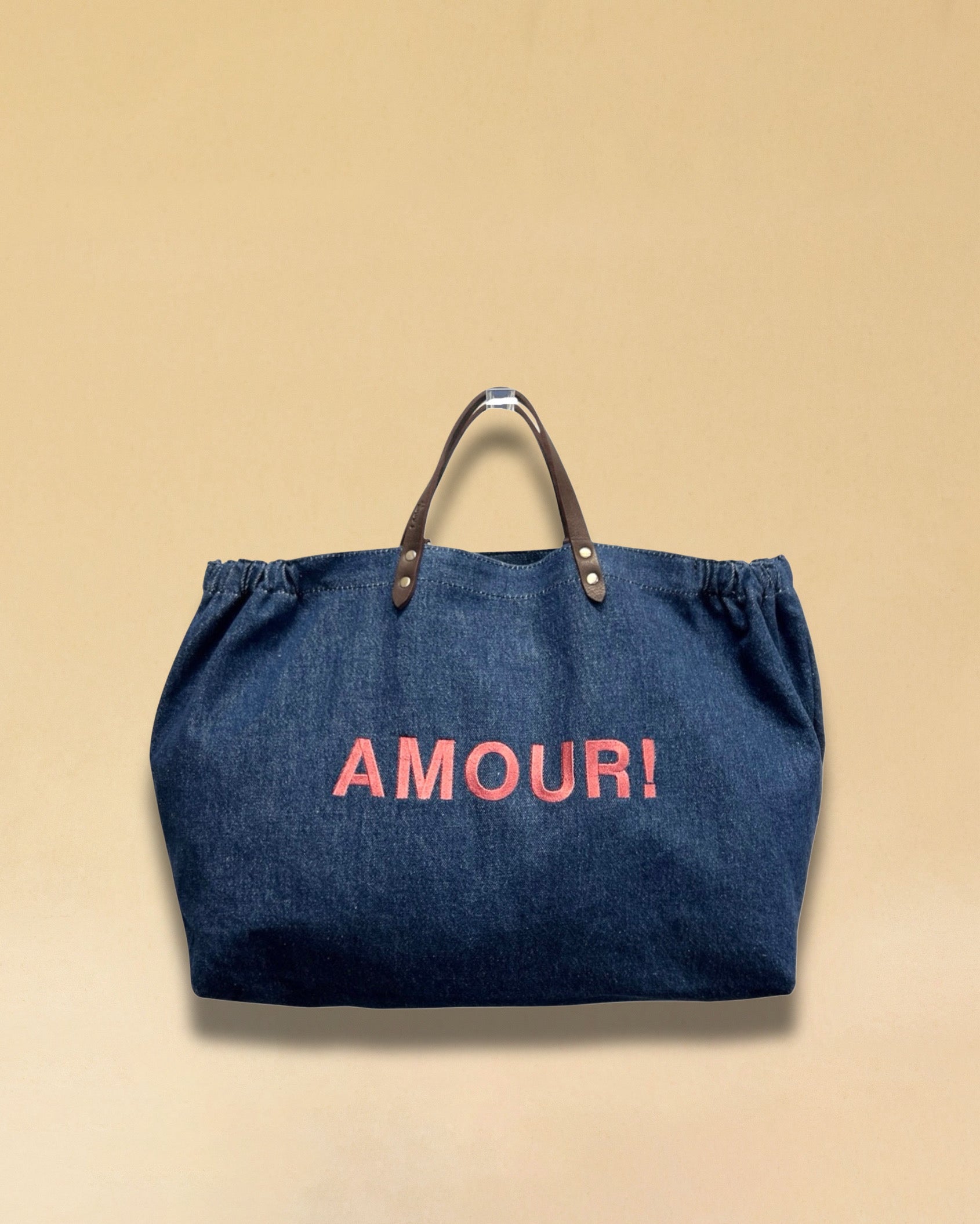 Bestickte Stofftasche von LABEL17 mit braunen Lederhenkeln und AMOUR Botschaft auf der Vorderseite. Hergestellt in Marokko