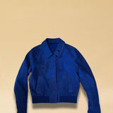 Die Lederjacke AMAL von LABEL17 in Azur-Bluelau besticht durch die kurze und figurschmeichelnde Passform. Sie harmoniert perfekt mit unserem Lederrock JACKIE. Gefertigt aus feinem Veloursleder, ist sie ein zeitloses Highlight für die Garderobe.