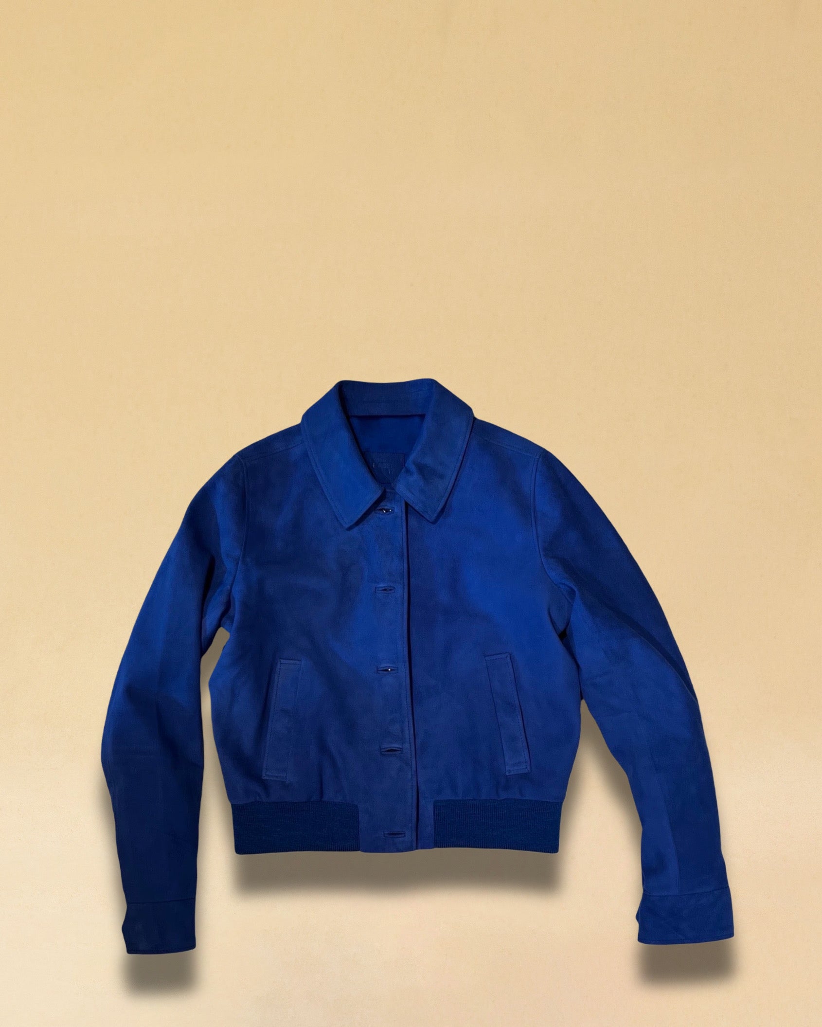 Die Lederjacke AMAL von LABEL17 in Azur-Bluelau besticht durch die kurze und figurschmeichelnde Passform. Sie harmoniert perfekt mit unserem Lederrock JACKIE. Gefertigt aus feinem Veloursleder, ist sie ein zeitloses Highlight für die Garderobe.