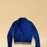 Die Lederjacke AMAL von LABEL17 in Azur-Bluelau besticht durch die kurze und figurschmeichelnde Passform. Sie harmoniert perfekt mit unserem Lederrock JACKIE. Gefertigt aus feinem Veloursleder, ist sie ein zeitloses Highlight für die Garderobe.