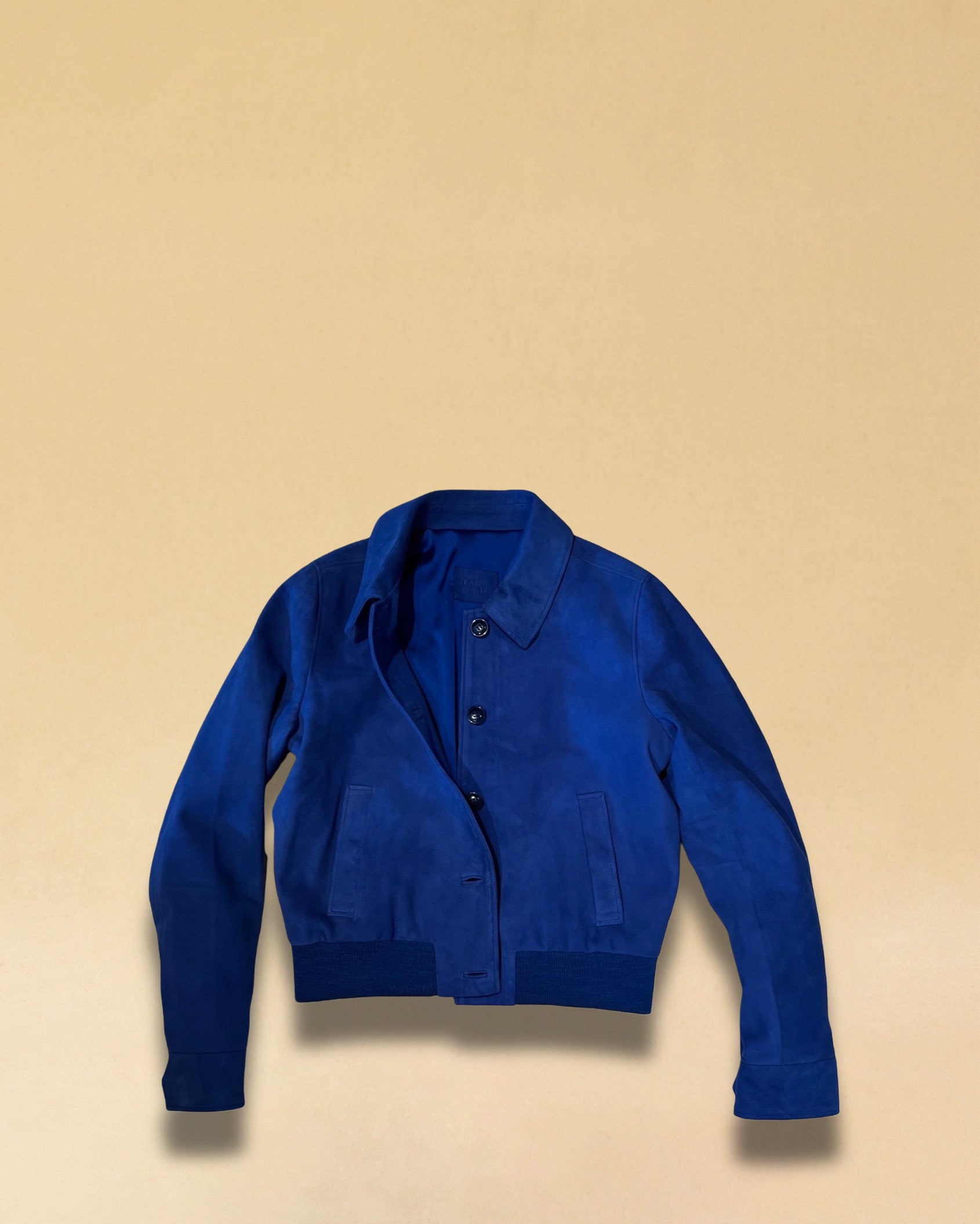 Die Lederjacke AMAL von LABEL17 in Azur-Bluelau besticht durch die kurze und figurschmeichelnde Passform. Sie harmoniert perfekt mit unserem Lederrock JACKIE. Gefertigt aus feinem Veloursleder, ist sie ein zeitloses Highlight für die Garderobe.