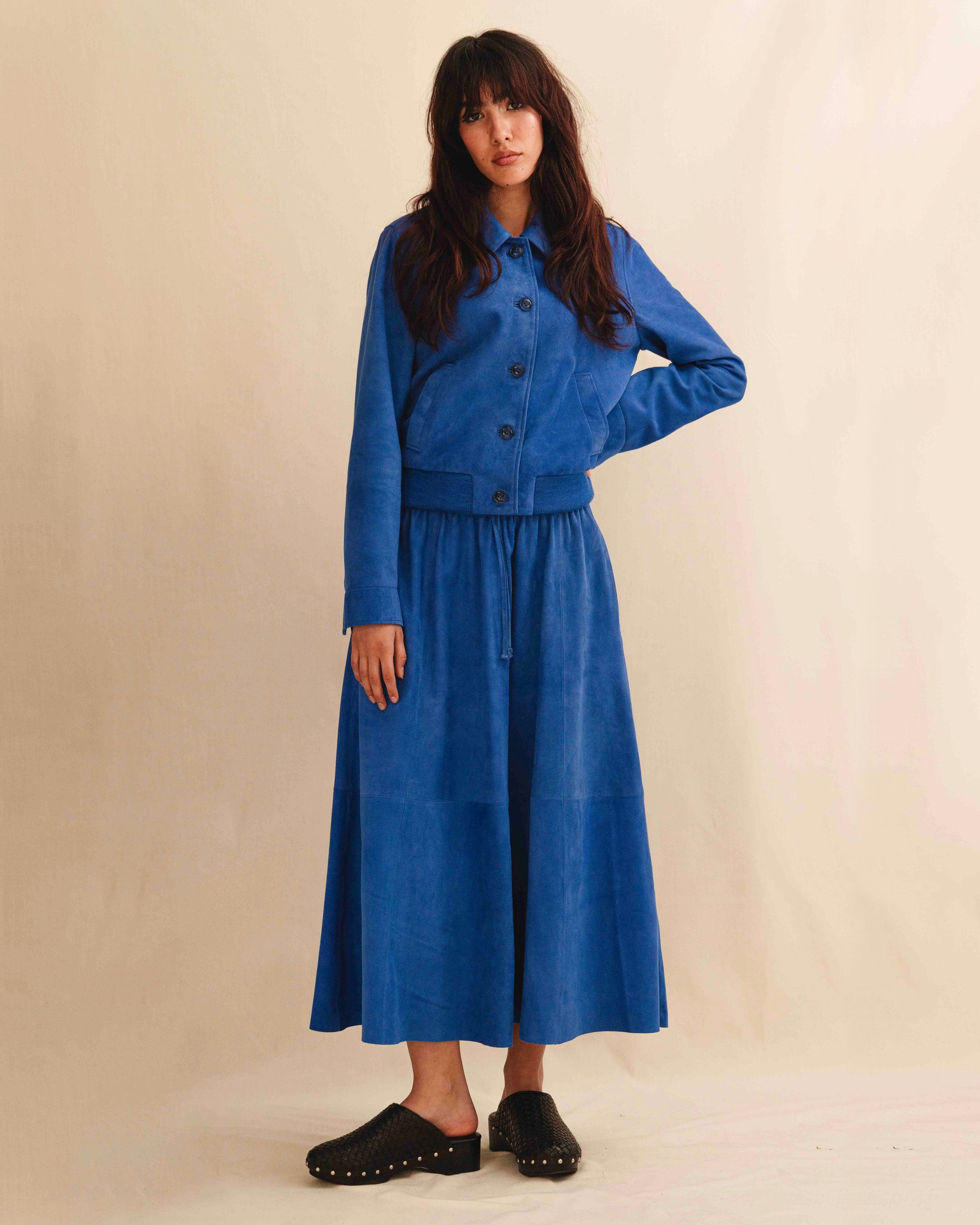 Die Lederjacke AMAL von LABEL17 in Azurblau besticht durch die kurze und figurschmeichelnde Passform. Sie harmoniert perfekt mit unserem Lederrock JACKIE. Gefertigt aus feinem Veloursleder, ist sie ein zeitloses Highlight für die Garderobe.