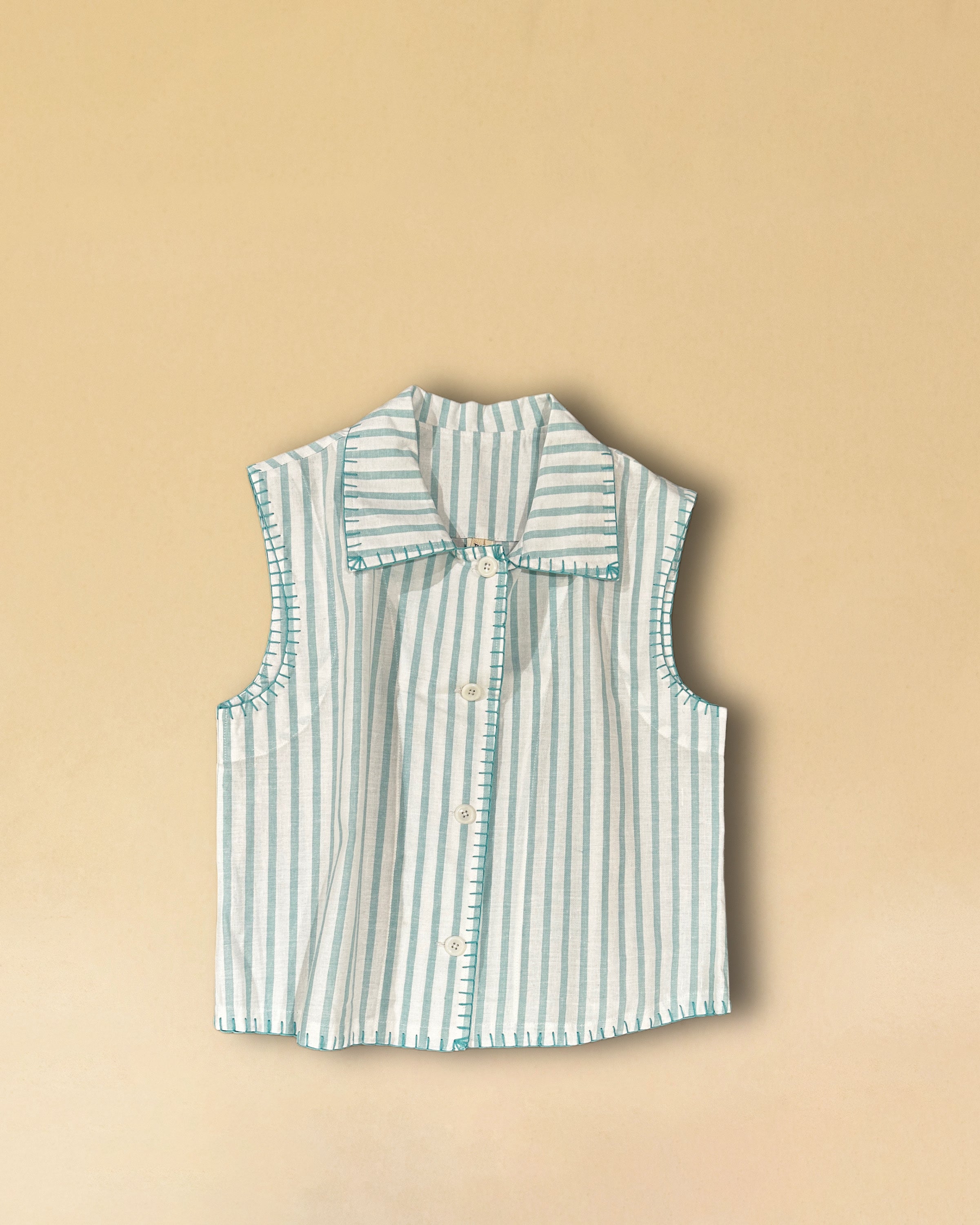 LABEL17's Vest LINDA aus hochwertiger Baumwolle ist eine ärmellose Veste, veredelt mit einem handgenähten Zierstich (Hbik-Stitch) in Türkis entlang der Knopfleiste, dem Kragen und dem Armloch.