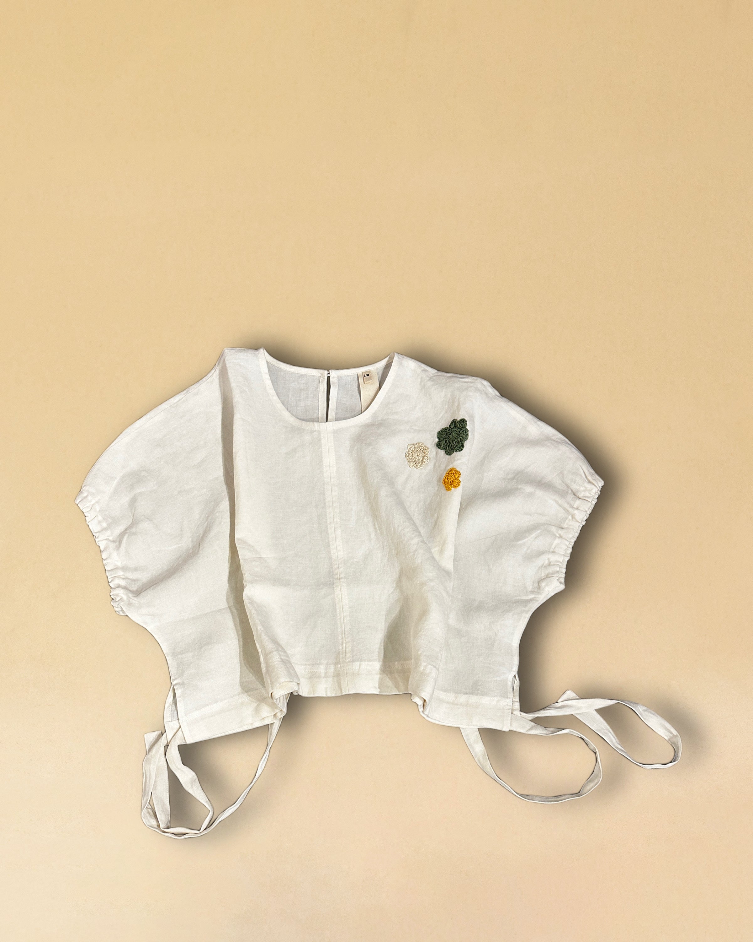 Die Drawstring Blouse LINA von LABEL17 hat einen runden Halsausschnitt und einen verstellbaren Tunnelzug am Saum. Aus einem leichten Leinen-Baumwoll-Mischgewebe ist dieses Top angenehm auf der Haut und ideal für warme Tage. Veredelt mit drei handgehäkelten Blumen in verschiedenen Grössen und Farben.