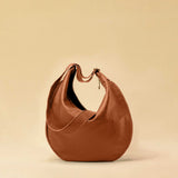 The Saddle Bag IVY by LABEL17 is crafted from supple, vegetable-tanned nappa leather and defined by its distinctive hand-stitched side seams. Its softly curved saddle silhouette rests comfortably against the body. The bag features a zip closure, a leather-lined interior, and a secure inner pocket. The adjustable strap allows it to be worn over the shoulder or crossbody – a versatile piece for everyday use. Handmade in Morocco.