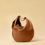 The Saddle Bag IVY by LABEL17 is crafted from supple, vegetable-tanned nappa leather and defined by its distinctive hand-stitched side seams. Its softly curved saddle silhouette rests comfortably against the body. The bag features a zip closure, a leather-lined interior, and a secure inner pocket. The adjustable strap allows it to be worn over the shoulder or crossbody – a versatile piece for everyday use. Handmade in Morocco.