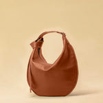 The Saddle Bag IVY by LABEL17 is crafted from supple, vegetable-tanned nappa leather and defined by its distinctive hand-stitched side seams. Its softly curved saddle silhouette rests comfortably against the body. The bag features a zip closure, a leather-lined interior, and a secure inner pocket. The adjustable strap allows it to be worn over the shoulder or crossbody – a versatile piece for everyday use. Handmade in Morocco.