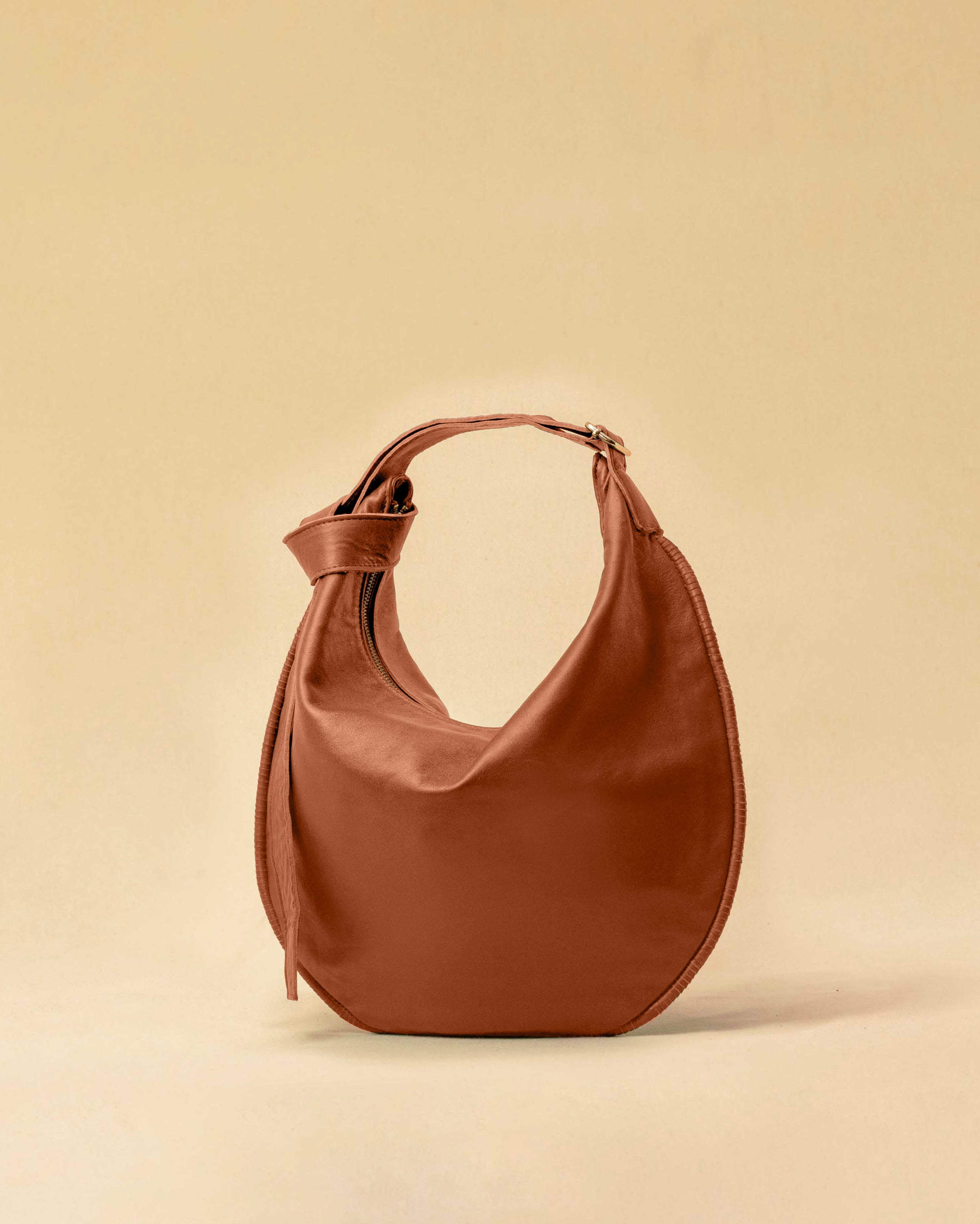 The Saddle Bag IVY by LABEL17 is crafted from supple, vegetable-tanned nappa leather and defined by its distinctive hand-stitched side seams. Its softly curved saddle silhouette rests comfortably against the body. The bag features a zip closure, a leather-lined interior, and a secure inner pocket. The adjustable strap allows it to be worn over the shoulder or crossbody – a versatile piece for everyday use. Handmade in Morocco.